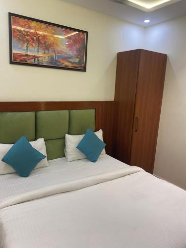 a bedroom with a bed with two blue pillows at Hotel Ramesh Palace in Prayagraj