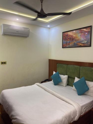 a bedroom with a large white bed with blue pillows at Hotel Ramesh Palace in Prayagraj