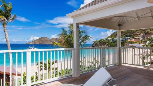 a balcony with a view of the beach and ocean at Luxurious Beachfront Villa in Flamands in Anse des Flamands