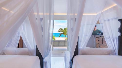a bedroom with two beds and a view of the ocean at Luxurious Beachfront Villa in Flamands in Anse des Flamands