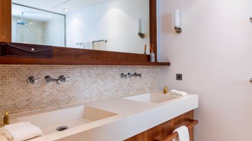a bathroom with a white sink and a mirror at Luxurious Beachfront Villa in Flamands in Anse des Flamands