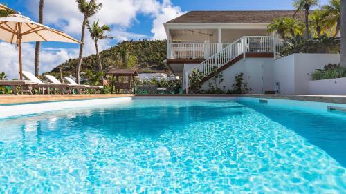a large swimming pool in front of a house at Luxurious Beachfront Villa in Flamands in Anse des Flamands