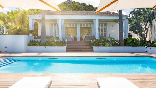 a house with a swimming pool in front of a house at Luxurious Beachfront Villa in Flamands in Anse des Flamands