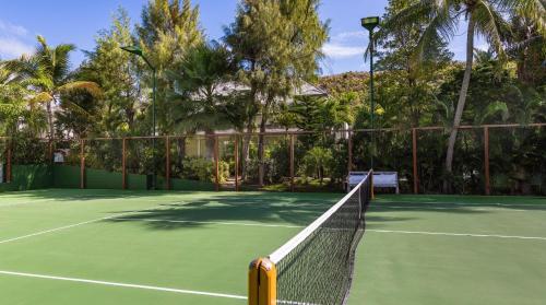 a tennis net on a tennis court with palm trees at Luxurious Beachfront Villa in Flamands in Anse des Flamands