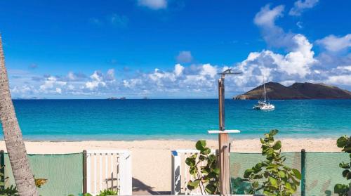 a view of a beach with a boat in the water at Luxurious Beachfront Villa in Flamands in Anse des Flamands