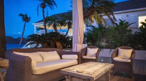 a couch and two chairs and a table on a patio at Luxurious Beachfront Villa in Flamands in Anse des Flamands