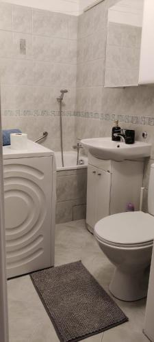a white bathroom with a toilet and a sink at Apartament Morze Bałtyckie in Gdańsk