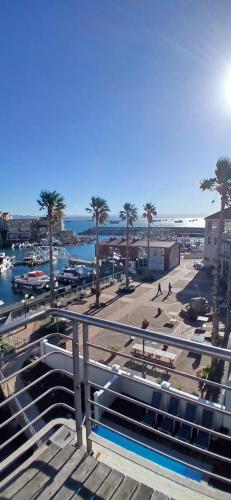 Una vista de un puerto deportivo con palmeras y un barco. en Shipsbell 2 bedroom, en Cape St. Francis