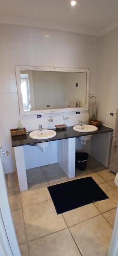 a bathroom with two sinks and a large mirror at Shipsbell 2 bedroom in Cape St Francis
