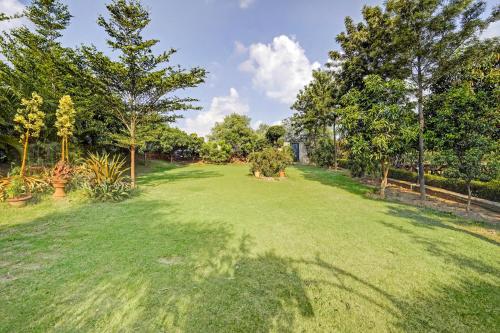 a large yard with green grass and trees at Alaya Stays Fortezza Pet-friendly 6-BHK Farmhouse With Private Pool, Gazebo & Lush Garden in Bhundsi