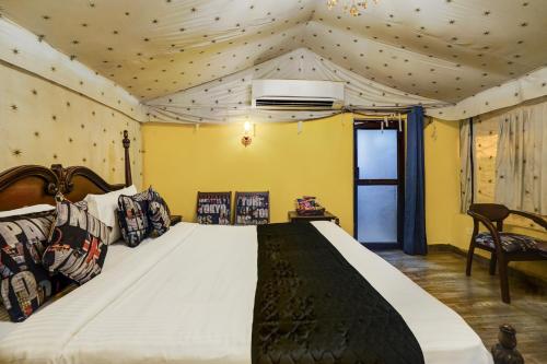 a bedroom with a large bed in a room with yellow walls at Alaya Stays Fortezza Pet-friendly 6-BHK Farmhouse With Private Pool, Gazebo & Lush Garden in Bhundsi