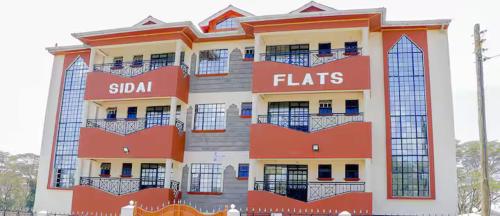 a tall building with red and white at Cosy 1 bedrooms, Hells Gate Moi South Lake Naivasha in Naivasha