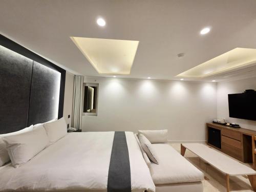 a bedroom with a large bed and a tv at Blueduck hotel in Seoul