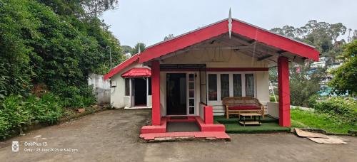 a small red and white house with a red roof at Nest 'N' Woods in Ooty