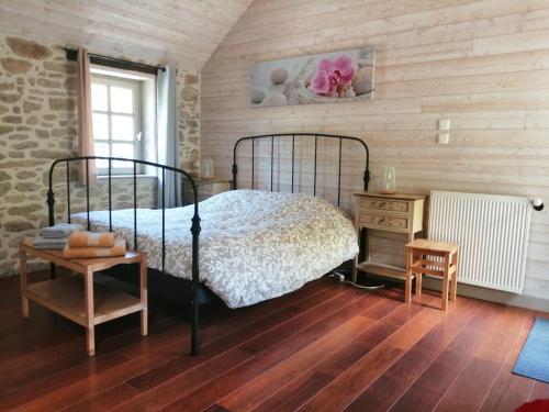 una camera da letto con un letto e un pavimento in legno di Chambres d'Hôtes du Moulin de Brendaouez a Guissény