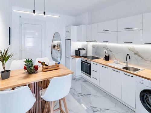 a white kitchen with white cabinets and white appliances at Sunny Nest Apartments in Ixia