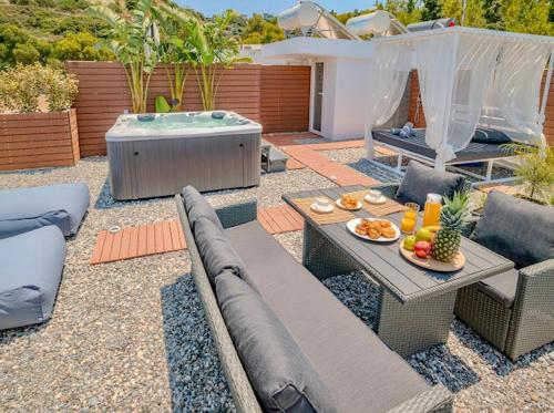 a backyard with a picnic table and a hot tub at Sunny Nest Apartments in Ixia