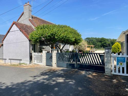 a white fence in front of a house at L'Escale Arc-en-Ciel in Les Hayes