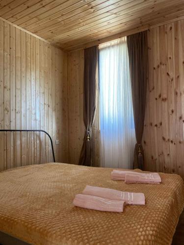 a bedroom with a bed with two pink towels on it at Green house Cottage in Itʼkhvisi