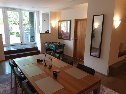 a dining room with a table with chairs and a mirror at Flammerie - Hoferstraße 30c in Gangelt