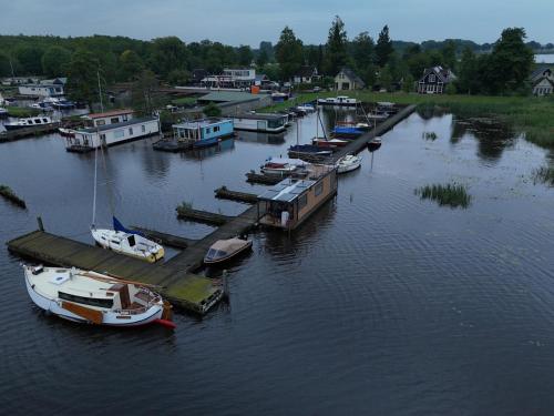 a group of boats docked at a dock in the water at Houseboat mét sloep in Midlaren