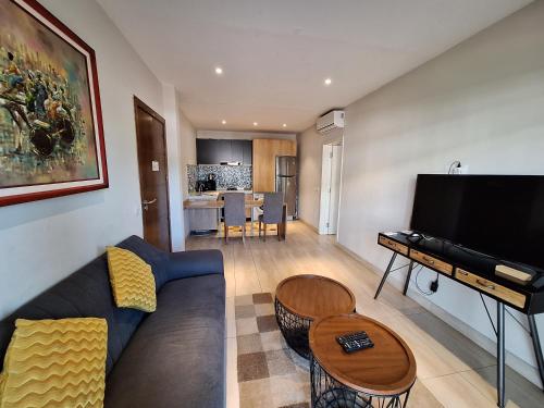 a living room with a couch and a flat screen tv at Forest View Apartments in Kololi