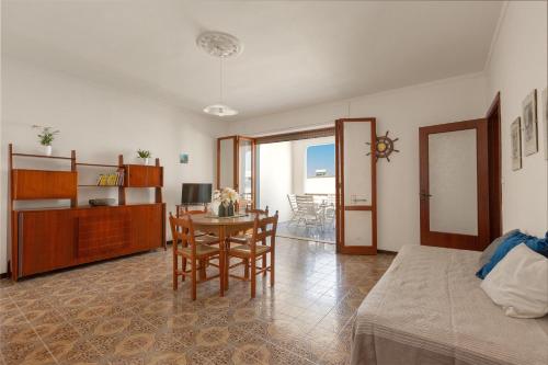 ein Wohnzimmer mit einem Bett und einem Tisch und Stühlen in der Unterkunft Balconcino Vista Mare by BarbarHouse in San Foca