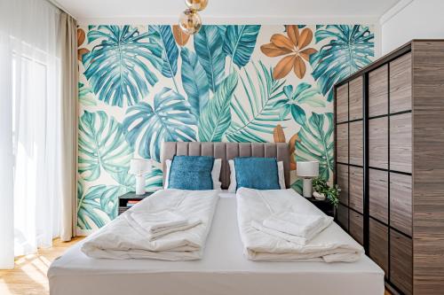 a bedroom with a bed with a tropical wallpaper at A60 Apartment Hotel in Budapest
