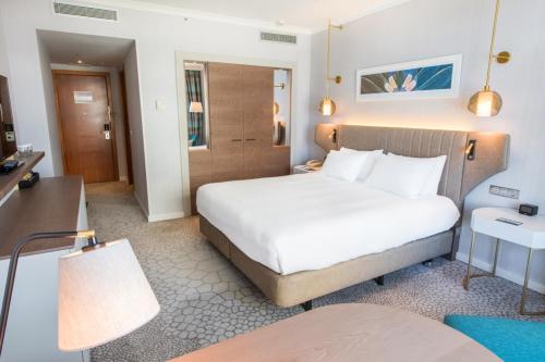 a hotel room with a large bed and a desk at Hilton Diagonal Mar Barcelona in Barcelona