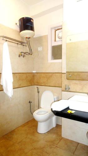 a bathroom with a toilet and a sink at Noel Home's Manali in Manāli