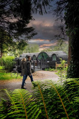 a man and woman walking in front of a building at The Forest at Mount Congreve Gardens in Kilmeaden