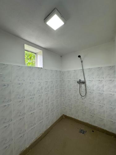 a white room with a shower and a window at Cabanutele lui Toader in Ceahlău