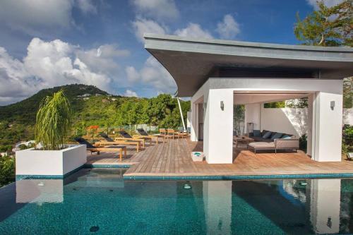 a house with a swimming pool next to a mountain at Luxurious Villa with Ocean Views in Saint-Jean