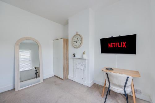 Una habitación con una mesa y un reloj en la pared. en Lutterworth House - Prime Location - Free Parking, Pool Table, Fast WiFi and Smart TV by Yoko Property, en Northampton