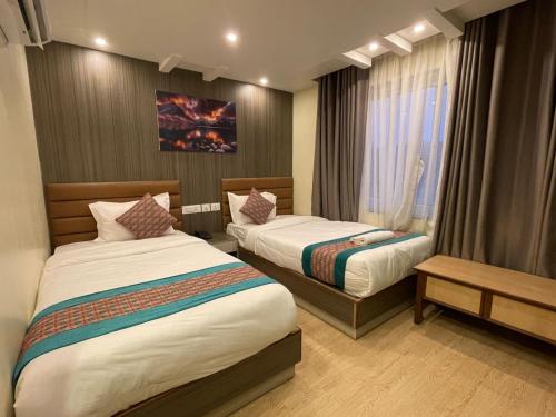 una camera d'albergo con due letti e una finestra di President Hotel Airport a Kathmandu
