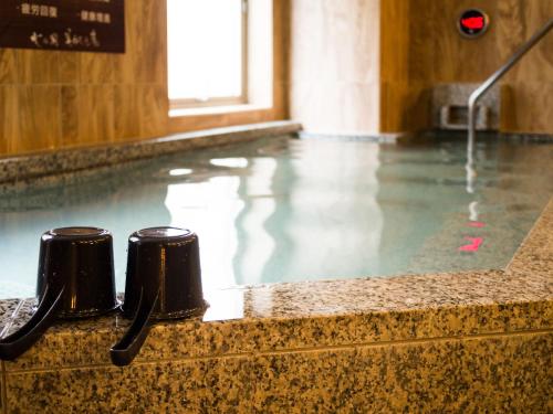 a swimming pool with water in a building at Natural Hot Spring SUPER HOTEL Kumamoto Chamber of Commerce in Kumamoto