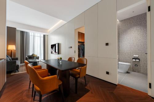 a dining room with a black table and orange chairs at IntercityHotel Chengdu New Exhibition Center in Chengdu
