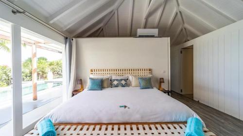 a bedroom with a large bed with a large window at Luxury Villa with Ocean View in St Barts in Saint-Jean