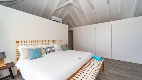 a bedroom with a large white bed and a bench at Luxury Villa with Ocean View in St Barts in Saint-Jean