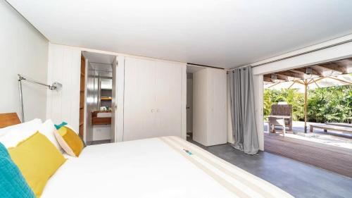 a bedroom with a large bed and a balcony at Luxury Villa with Ocean View in St Barts in Saint-Jean