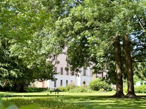 a large white building with trees in front of it at Friesenhus - Jever in Jever