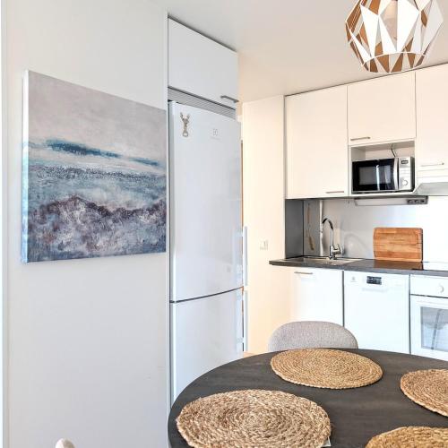a kitchen with a table with chairs and a refrigerator at Henniina V Kotoisa - Free parking & Easy Check-in in Oulu