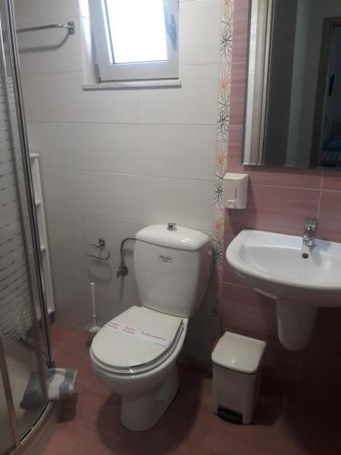 a bathroom with a toilet and a sink at olivensun apartment 6 in Gythio