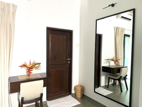 a mirror in a room with a desk and a sink at Samadhi Lagoon Villa in Rathgama