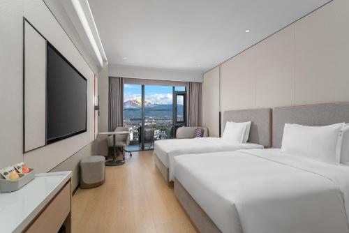 a hotel room with two beds and a flat screen tv at Holiday Inn Express Lijiang Ancient Town by IHG in Lijiang