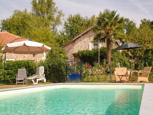 a swimming pool with chairs and umbrellas and a house at Romantic cottage with shared swimming pool in Roussines