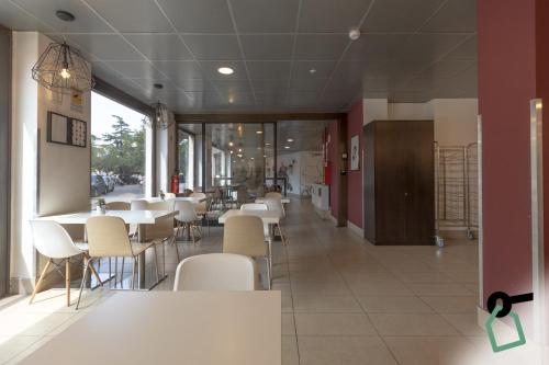 a dining room with white tables and white chairs at Hotiday Firenze Guidoni in Florence