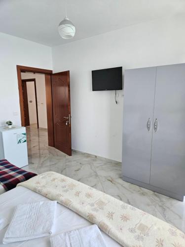 a bedroom with a bed and a flat screen tv at Vila Vako in Pogradec