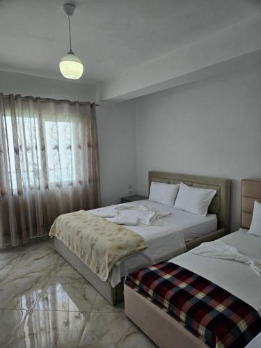 a bedroom with two beds and a window at Vila Vako in Pogradec