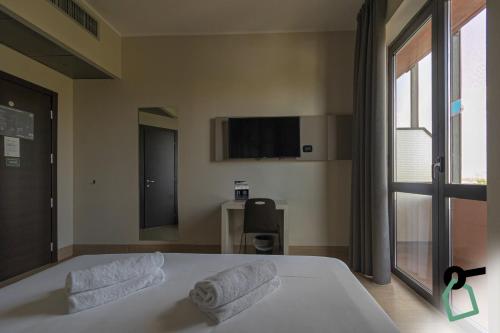 a bedroom with a bed and a tv on the wall at Hotiday Firenze Guidoni in Florence